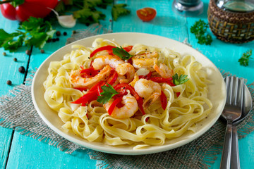 Italian pasta tagliatelle with shrimp and sweet peppers paprika,
