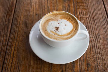 Hot cappuccino coffee on wooden table
