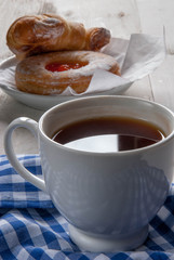 Sweet breakfast or snack. Freshly brewed black tea and fragrant homemade cakes on a rustic wooden table. 