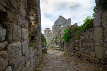 Fototapeta na wymiar Vintage old street in castle with brick stone walls, dark ground and mistic sky.