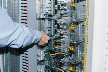 Electrician near the low-voltage cabinet. Uninterrupted power supply. Electricity.