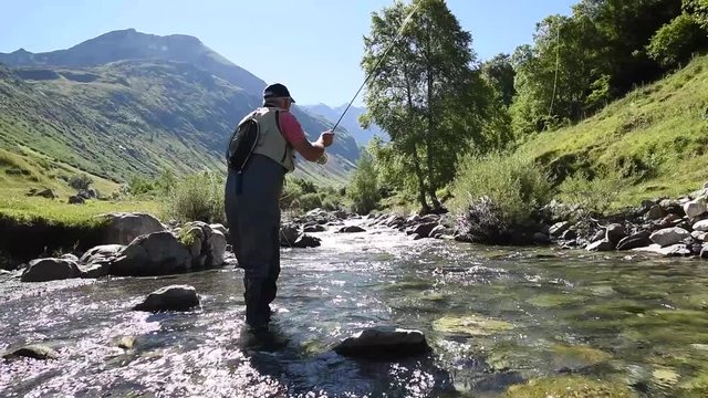 Fisherman fly-fishing in Pyrenees mountain river