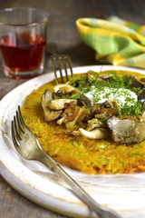 Fried potato pancake with mushrooms and onion.