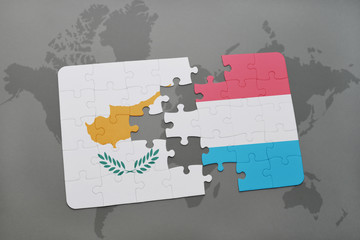 puzzle with the national flag of cyprus and luxembourg on a world map background.
