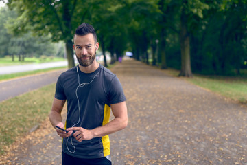 Attraktiver Mann hört Musik auf dem Smartphone