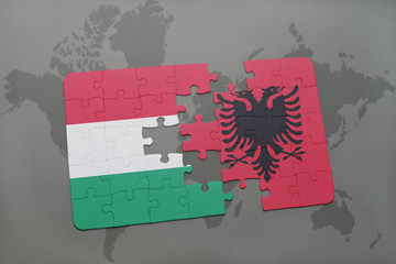 puzzle with the national flag of hungary and albania on a world map background.