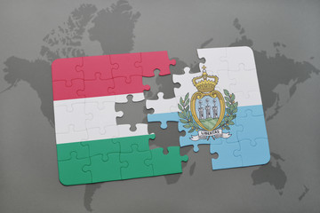 puzzle with the national flag of hungary and san marino on a world map background.