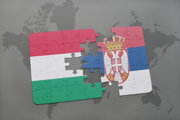 puzzle with the national flag of hungary and serbia on a world map background.