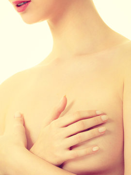 Woman covering her breast with hands