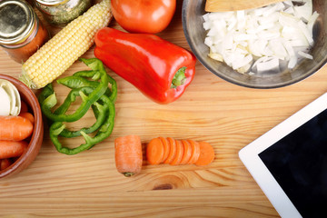 Vegetables, cut carrot and seasonings for cooking with tablet.