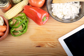 Vegetables and seasonings with a digital tablet.