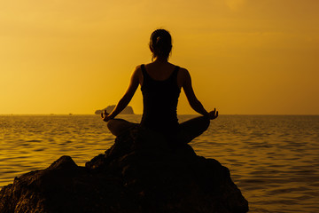 Silhouette yoga meditation girl on the background of the sea and