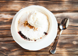 Tasty dessert with an ice cream ball on a wooden background