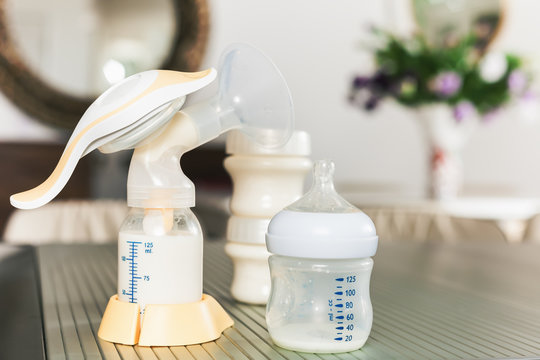 Baby bottle with milk and manual breast pump