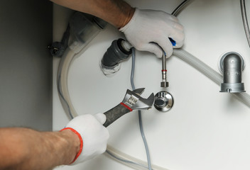 Plumber attaches flexible tube to the faucet.