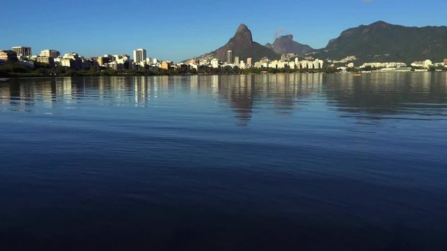 Scenic skyline morning time lapse of Lagoa Rodrigo de Freitas lagoon in Rio de Janeiro Brazil with Ipanema and Leblon reflecting on the calm horizon 
