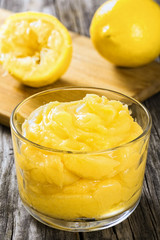 lemon curd in cup with half of squeezed lemon