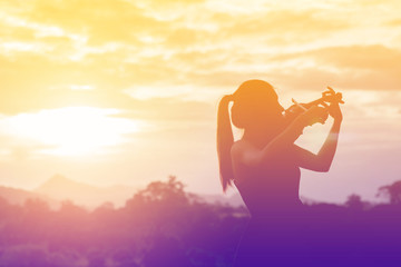 Silhouette women play violin sunset background