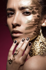 Obraz premium Beautyful girl with gold glitter on her face. Art image beauty