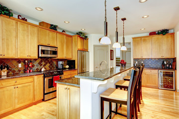 Kitchen room with brown cabinets, stainless steel, granite counter top.