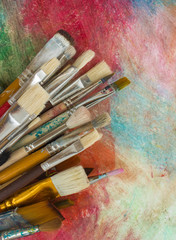 Fototapeta premium Brushes on a colorful background. The workplace of the artist. Banner for school