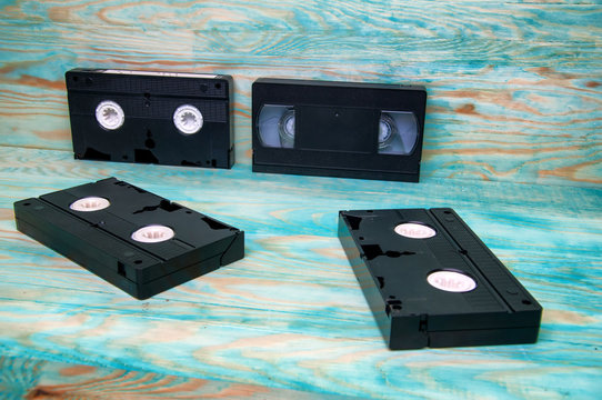 Old VHS tapes cassettes on blue wooden background