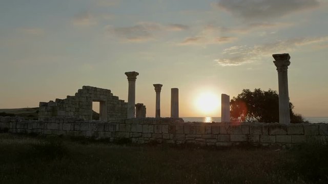 Ancient Greek basilica and marble columns in Chersonesus Taurica on the sunset background.