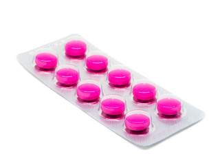 pink tablets pills in blister pack isolated on white background.