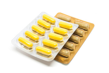 green yellow herb capsules pills in gold silver blister pack
