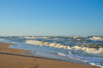 sea, waves, sandy beach and blue sky