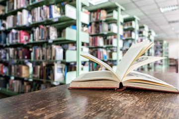 Old books open on wooden table in library, education and learning