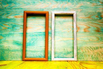 Old abstract picture frames on colored wooden background