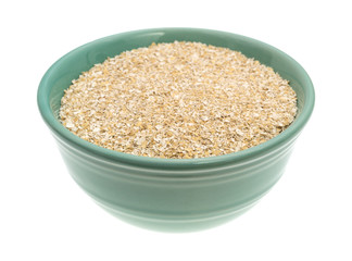 Dry oat bran hot cereal in a green bowl isolated on a white background side view.