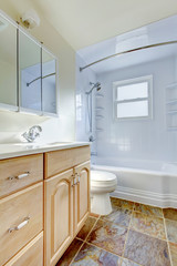 Fototapeta na wymiar Bathroom interior with light tone vanity cabinet and tile floor.