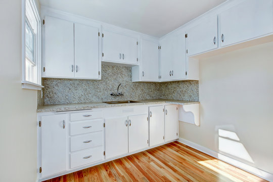 White kitchen cabinets with light tone hardwood floor