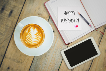 Happy Tuesday on paper with coffee cup on wood background