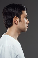 Portrait of young man after shaving over grey background.