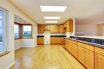 Spacious kitchen room with cabinets and black granite tops.