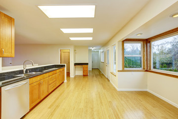 Spacious kitchen room with cabinets and black granite tops.