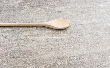 Wooden spoon on stone table. Traditional cooking equipment. Wood kitchenware object used for food,...