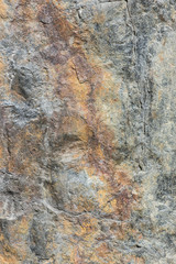 Stone background, rock wall backdrop with rough texture. Abstract, grungy and textured surface of stone material. Nature detail of rocks.