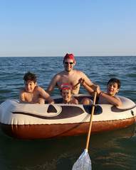Obraz premium three brothers with their father on the dinghy in the sea
