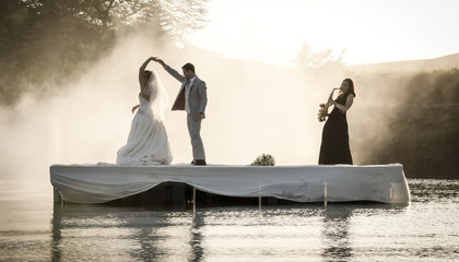 Bride and Groom dancing on a lake to music.