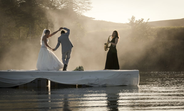 Bride and Groom dancing on a lake to music.