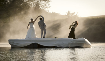 Bride and Groom dancing on a lake to music.