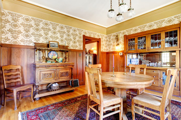 Open floor plan antique dining area with wooden pannel trim