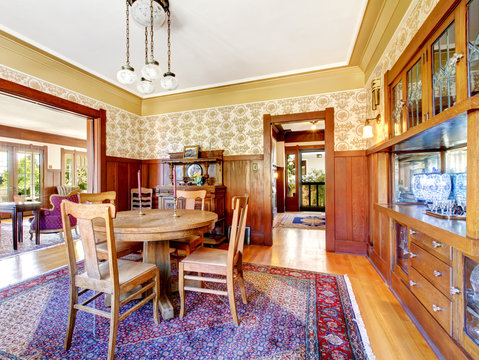 Open floor plan antique dining area with wooden pannel trim