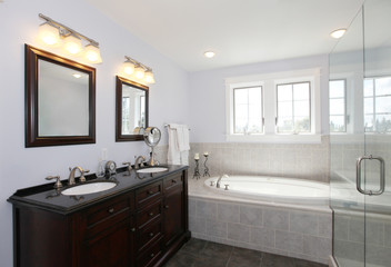 Fototapeta na wymiar Bathroom with tub and wood cabinet with two sinks