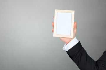 Businessman holding blank picture frame