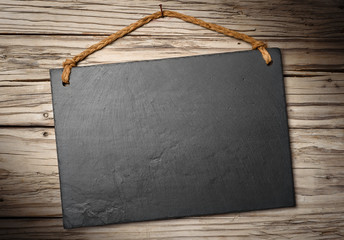 black slate signboard on aged wooden wall